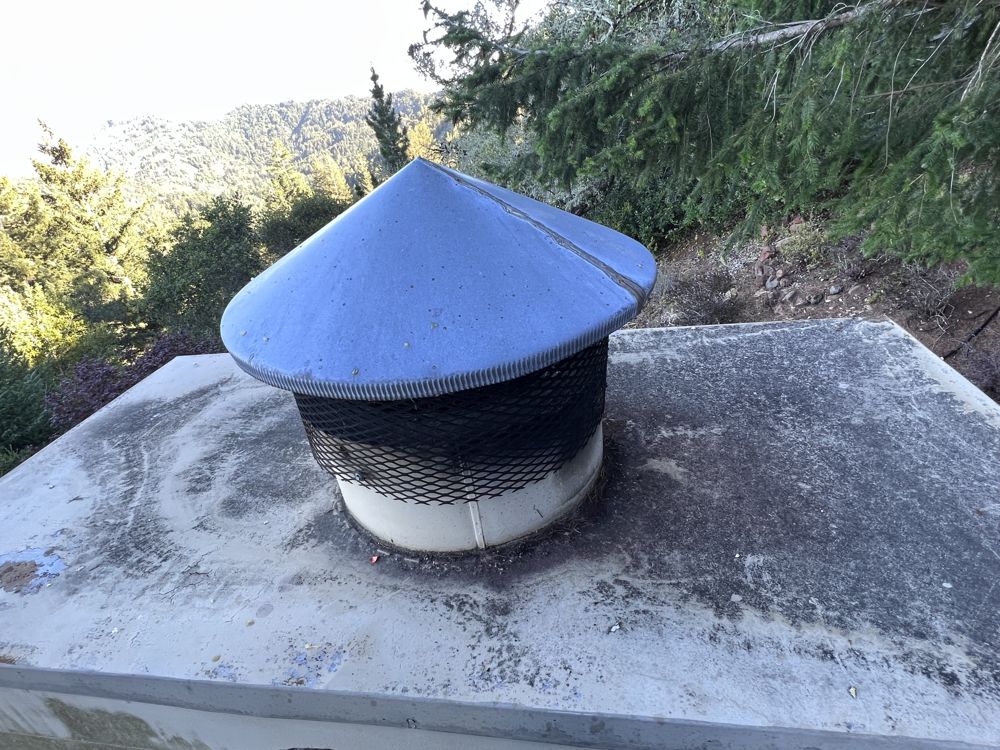 Cone chimney cap with spark screen on a masonry chimney