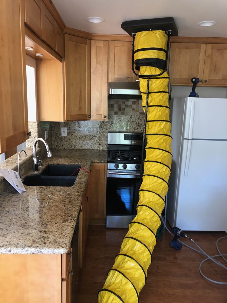 Duct cleaning equipment routed through a kitchen