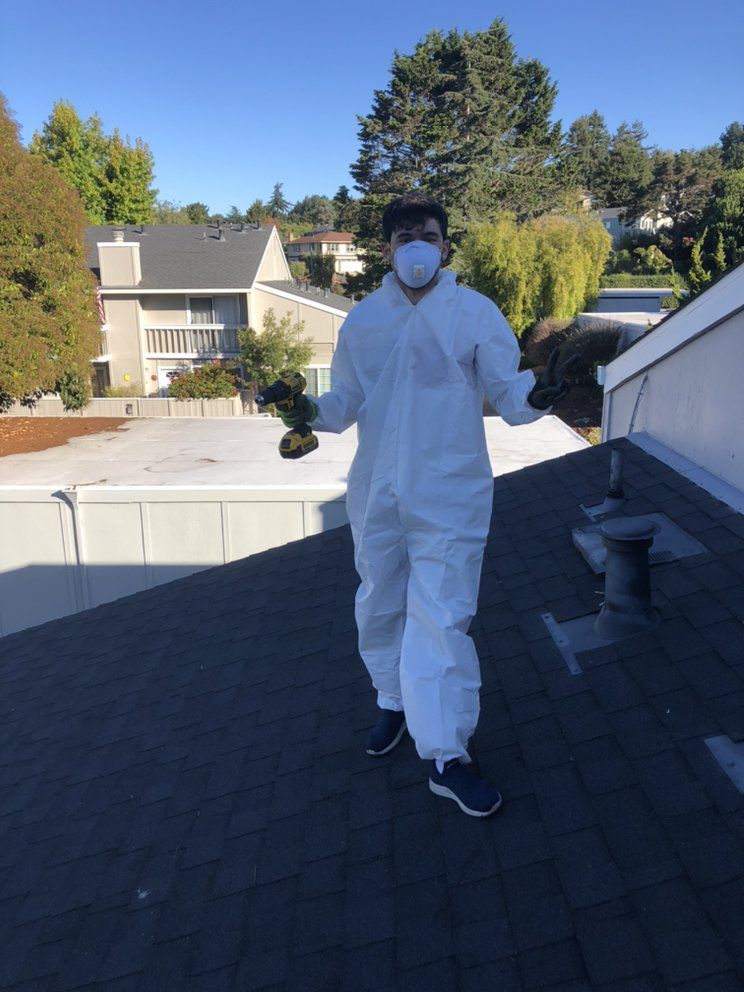 Cal Duct Cleaning technician in protective gear servicing rooftop vents